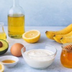 Zutaten für natürliche Haarkur mit Avocado, Banane, Honig, Joghurt, Ei, Öl und Zitrone.